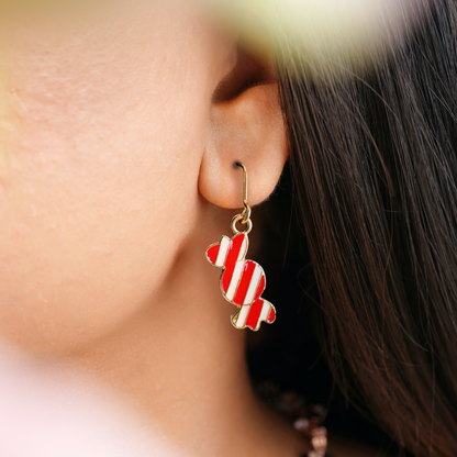 woman wearing candy cane earrings