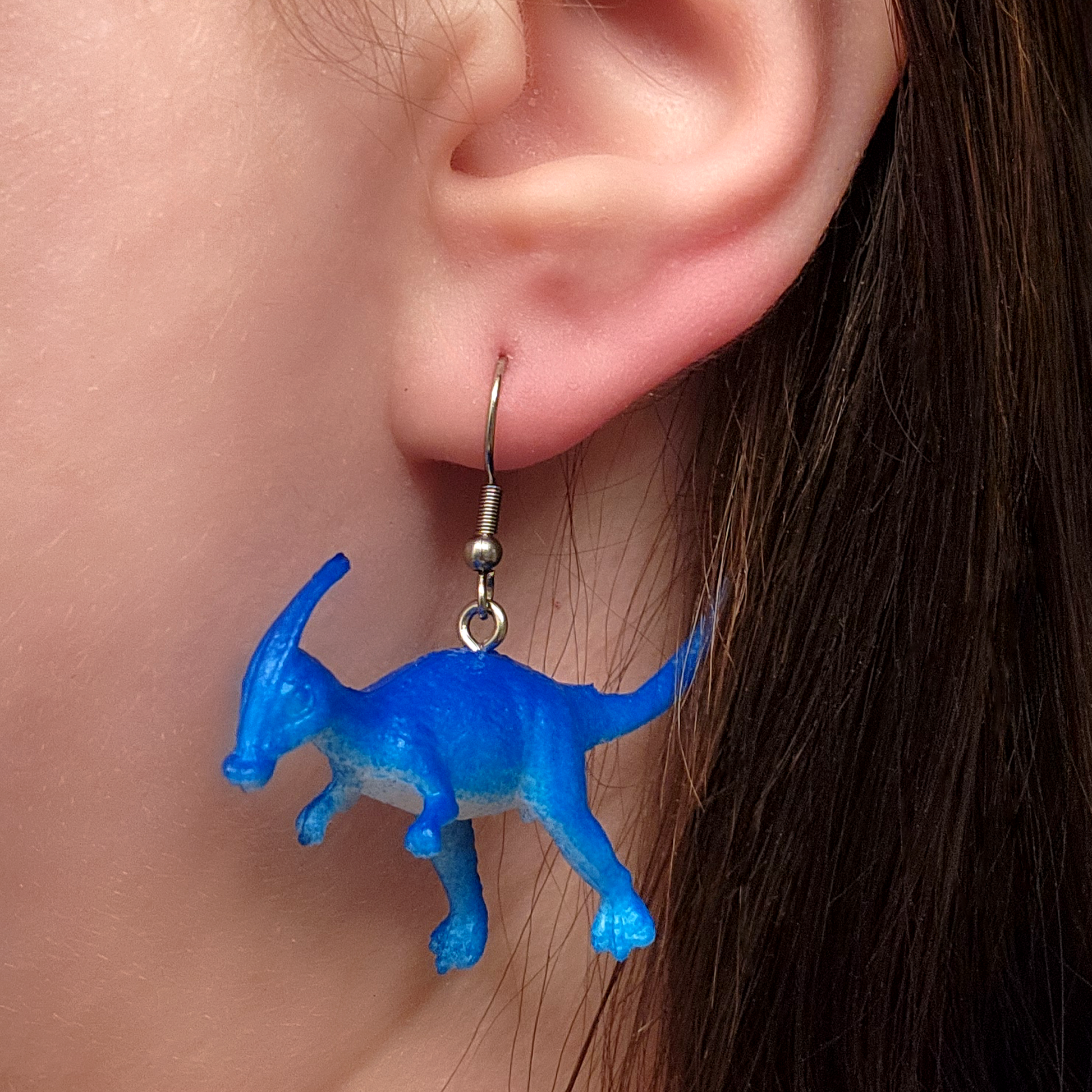 woman wearing dinosaur earrings