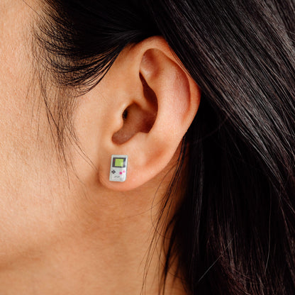 woman wearing handheld retro game console earrings